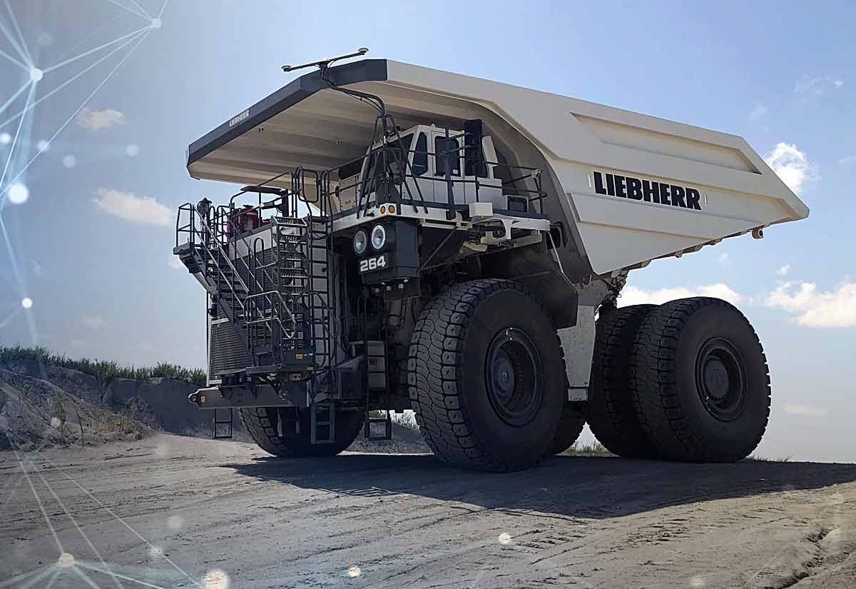 Autonomous zero-emission ultra-class haul truck operating on an open-pit mine haul road under overhead charging infrastructure.